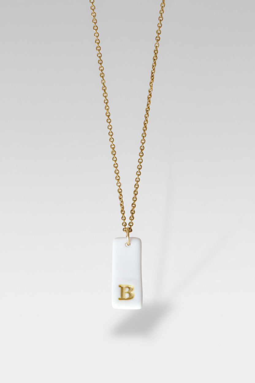 Gold Necklace with a white handmade porcelain pendant featuring a gold letter 'B'
