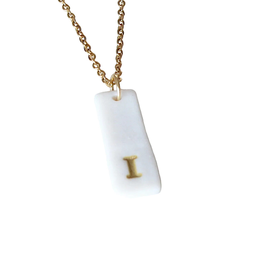Gold Necklace with a white handmade porcelain pendant featuring a gold letter 'I'