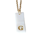 Gold Necklace with a white handmade porcelain pendant featuring a gold letter 'G'