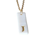 Gold Necklace with a white handmade porcelain pendant featuring a gold letter 'J'