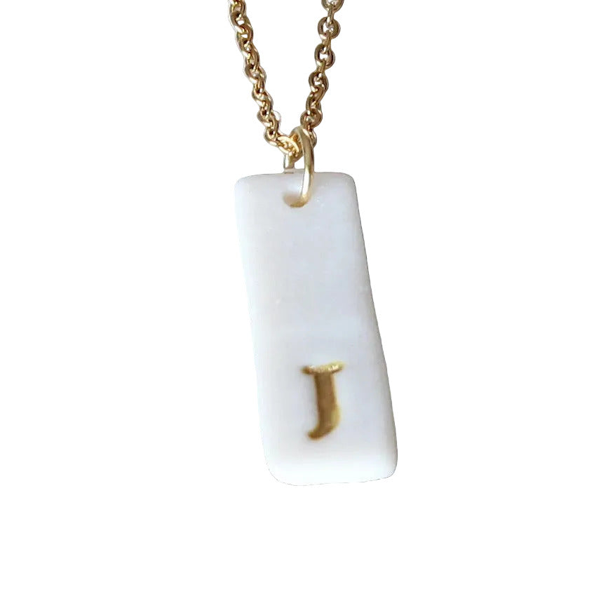 Gold Necklace with a white handmade porcelain pendant featuring a gold letter 'J'