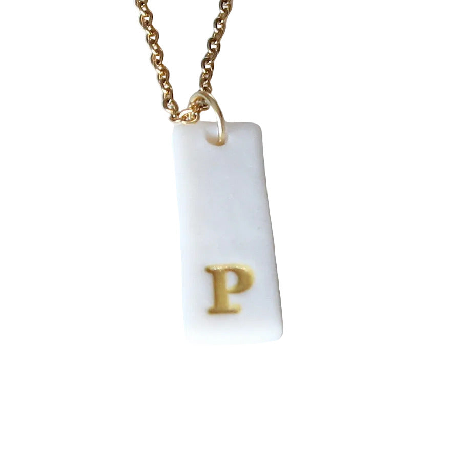 Gold Necklace with a white handmade porcelain pendant featuring a gold letter 'P'
