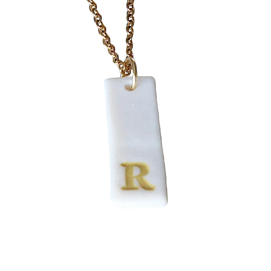 Gold Necklace with a white handmade porcelain pendant featuring a gold letter 'R'
