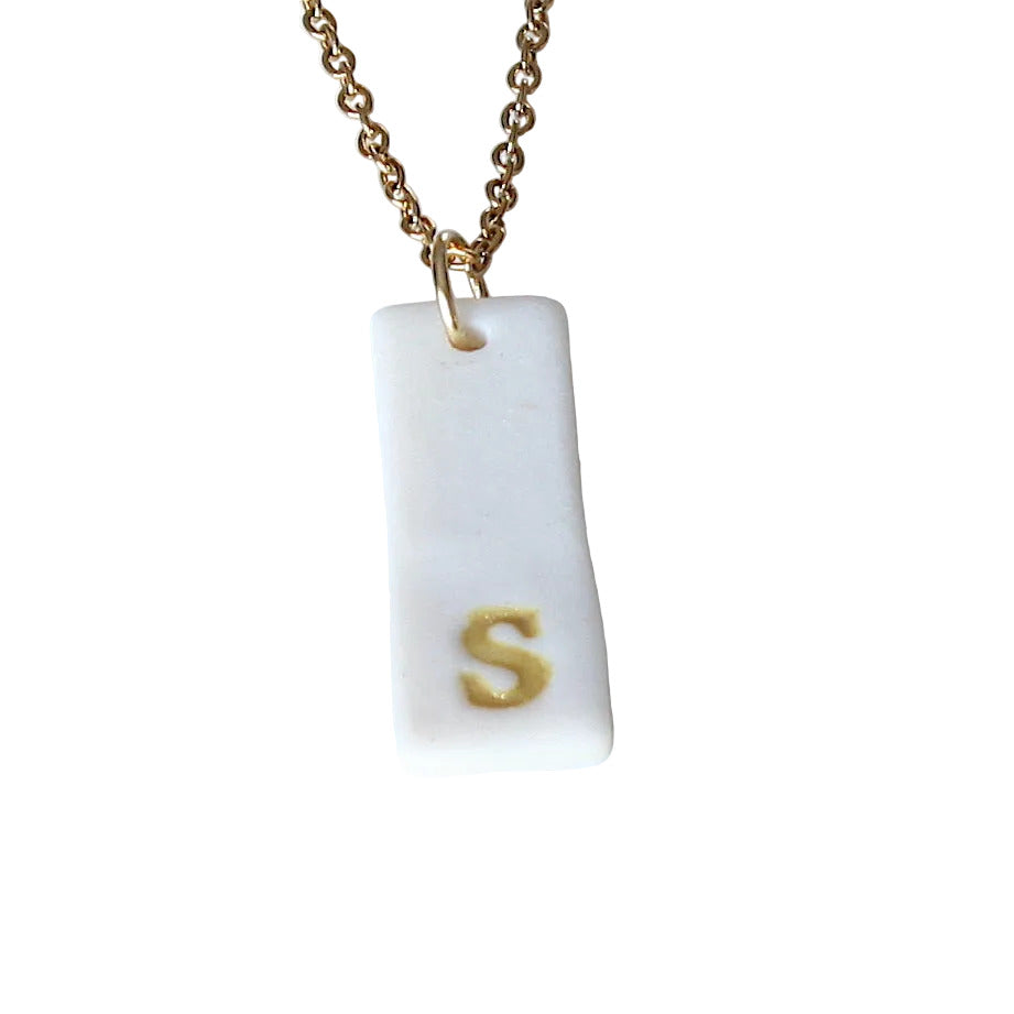 Gold Necklace with a white handmade porcelain pendant featuring a gold letter 'S'